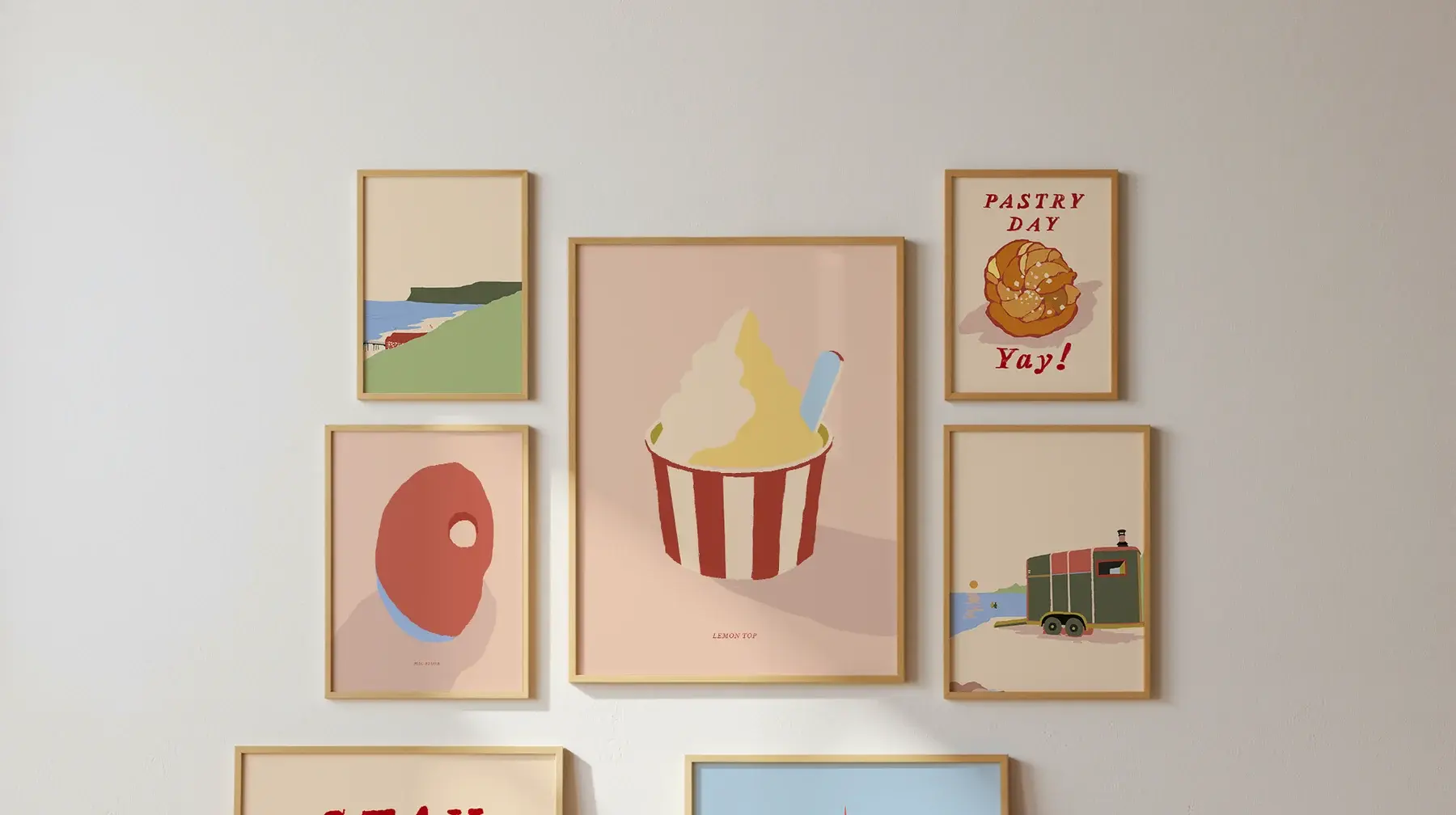 A wall of Pikku Prints framed in oak, with more leaning against the skirting below
